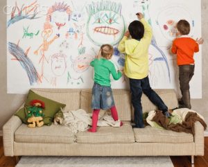 Little kids drawing on a wall